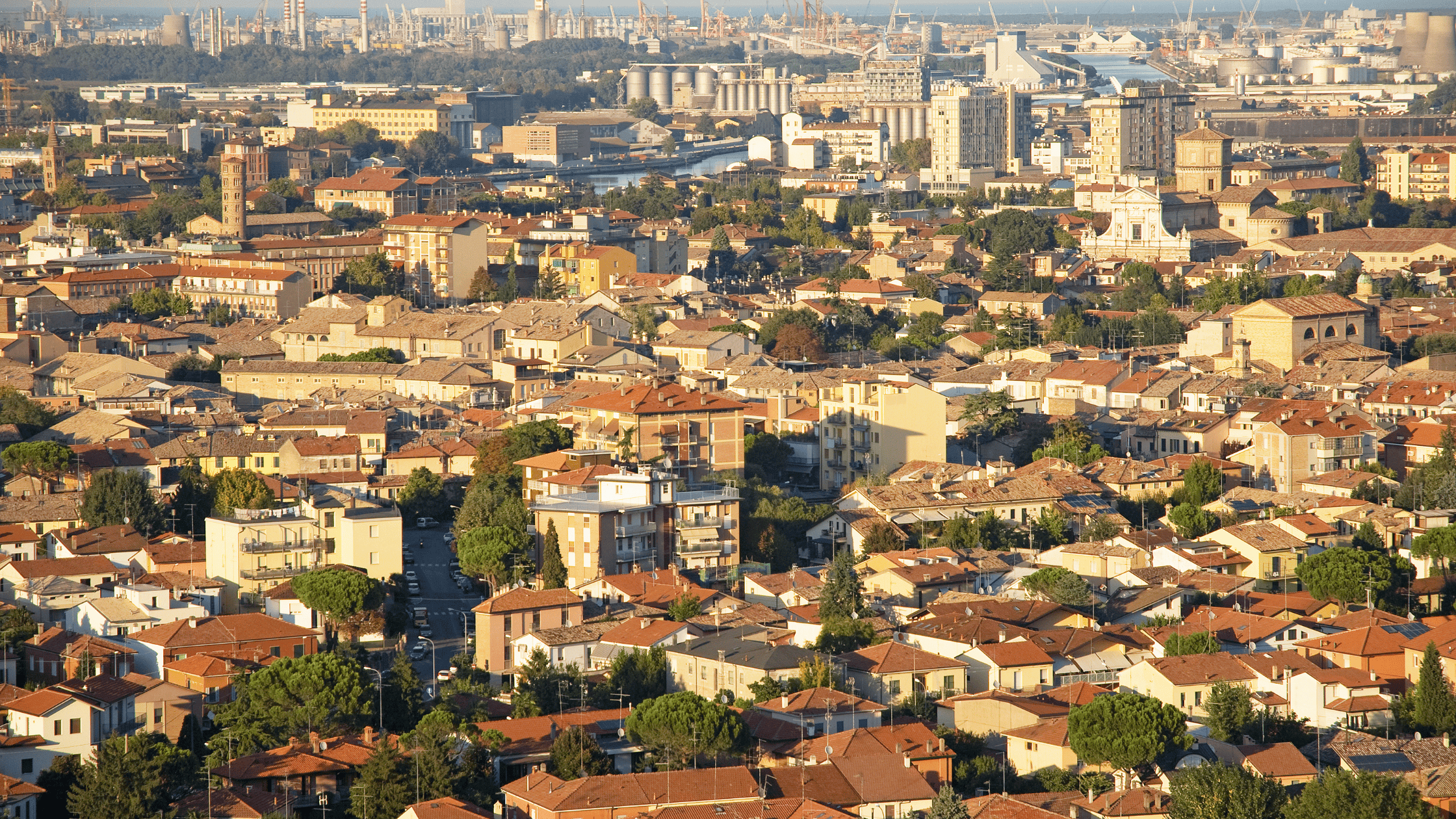  Aerial view of the cityscape of Ravenna, Italy, showcasing a mix of historic architecture and modern buildings under a clear sky.
